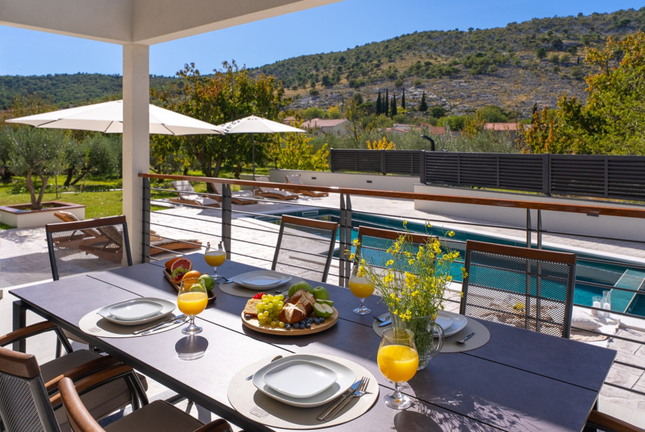 Covered outdoor dining area for 10, ideal for al fresco meals and mornings by the pool.
