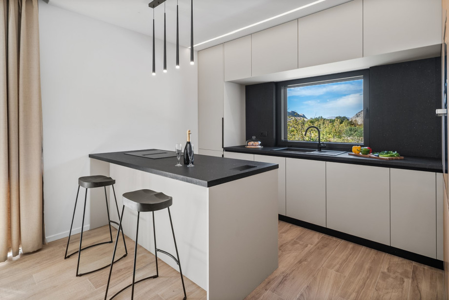 The sleek kitchen island, complete with modern appliances, is perfect for preparing homemade meals or enjoying a morning coffee.