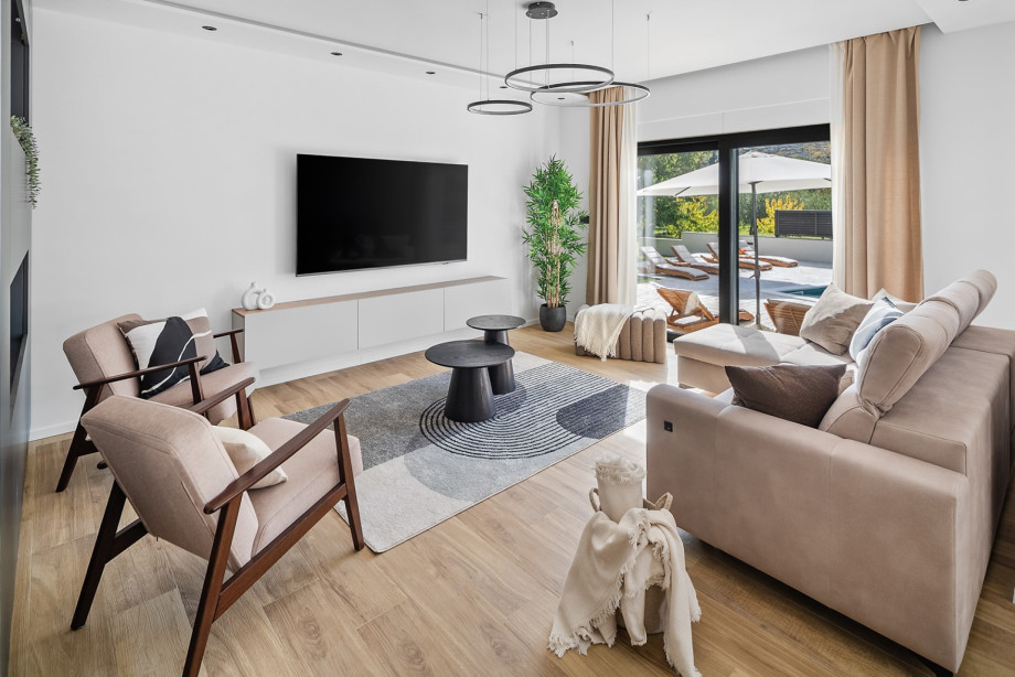 The sun-drenched living room offers cosy seating and a seamless transition to your private outdoor paradise.