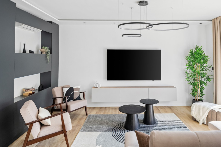 A stylish, air-conditioned living area featuring minimalist design, a flat-screen TV, and modern décor.