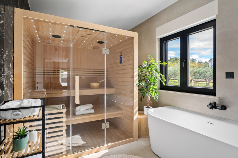 Private relaxation zone featuring a Finnish sauna and a luxury bathtub with garden views.