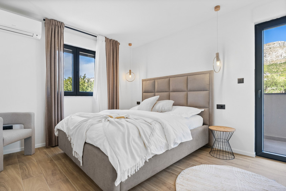 Bedroom 3 offers a queen-size bed, a minimalist vanity, and a private balcony overlooking the village.