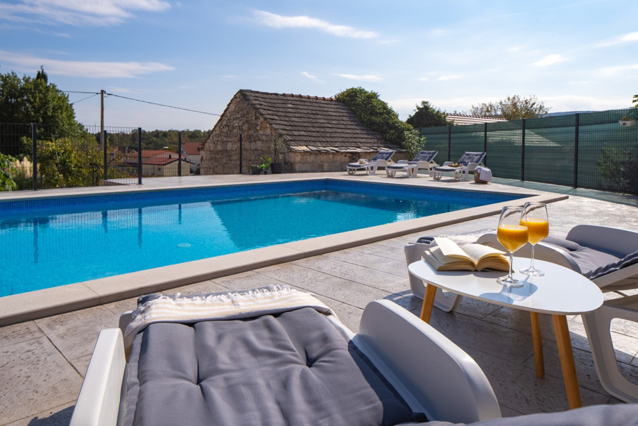 The inviting poolside offers comfortable seating and sun loungers, perfect for indulging in a book or soaking up the sun with a refreshing drink.