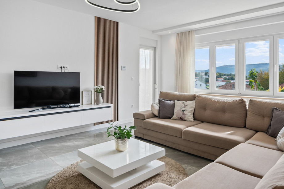 The modern and bright spacious living room offers comfortable seating and a TV, all within the fully air-conditioned living space.