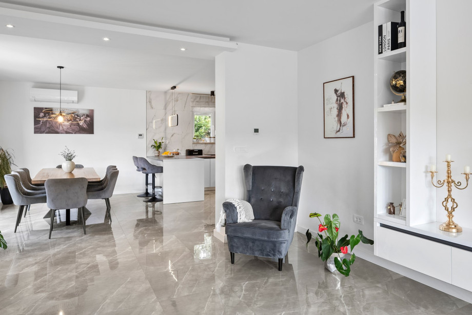 The open-plan design connects the spacious living room seamlessly with the dining area and the fully equipped kitchen on the first floor.