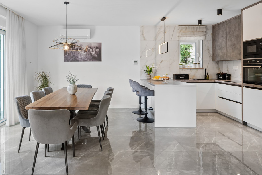 The first floor's fully equipped kitchen features a central kitchen island and a dedicated dining table for enjoyable gatherings.