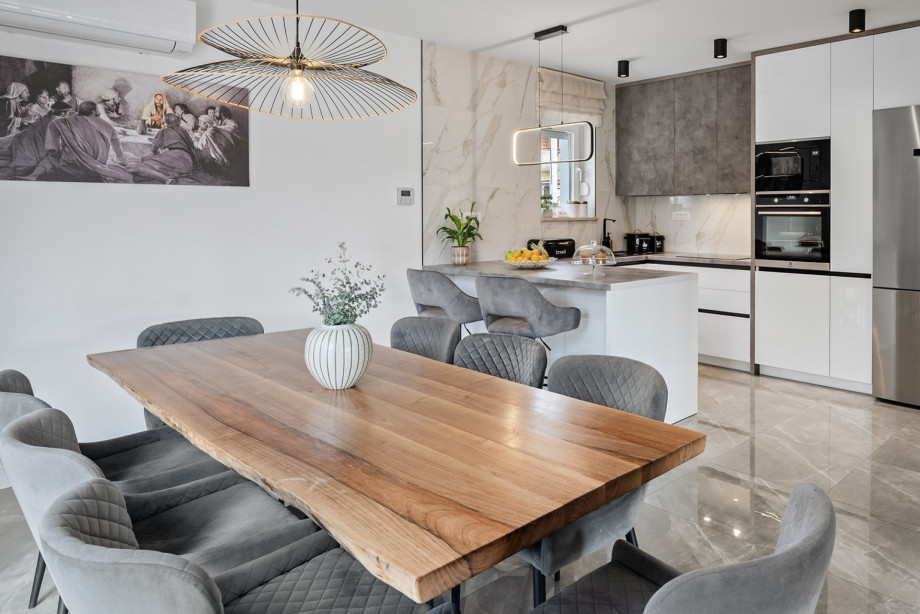 The fully equipped kitchen, complete with a kitchen island and a spacious dining table, forms the heart of the main living area.