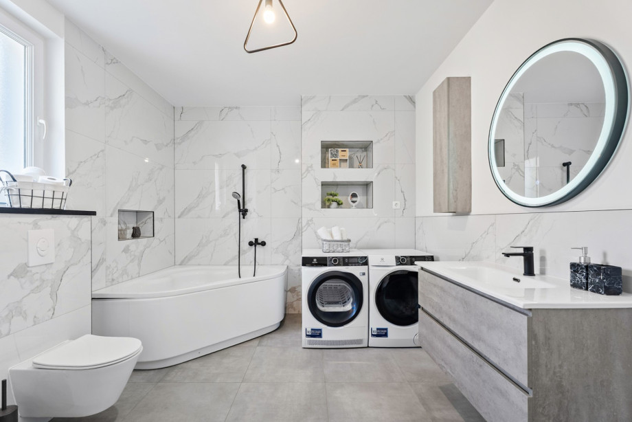 The family bathroom on the first floor features a bathtub, a toilet, a washing machine, and a dryer for guest convenience.