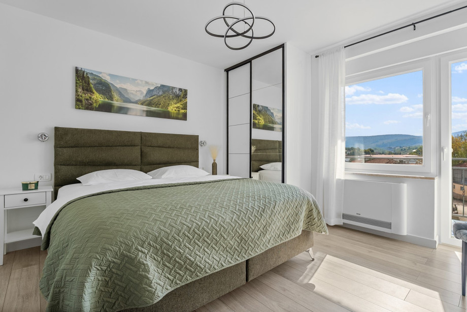 Bedroom 2 includes a King-sized bed, air conditioning, and a window with views of the surroundings.