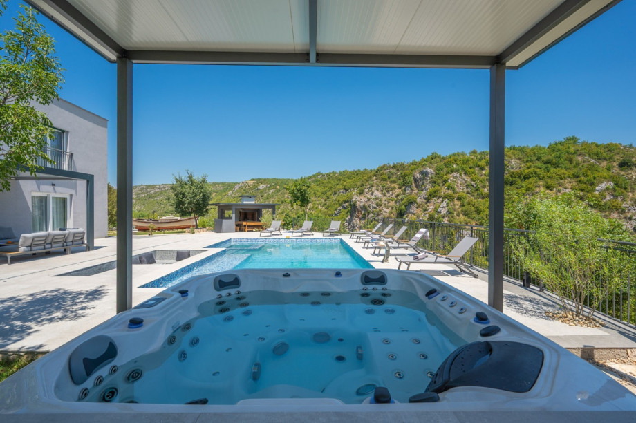 View from the covered hot tub looking across the water toward the distant mountain peaks.