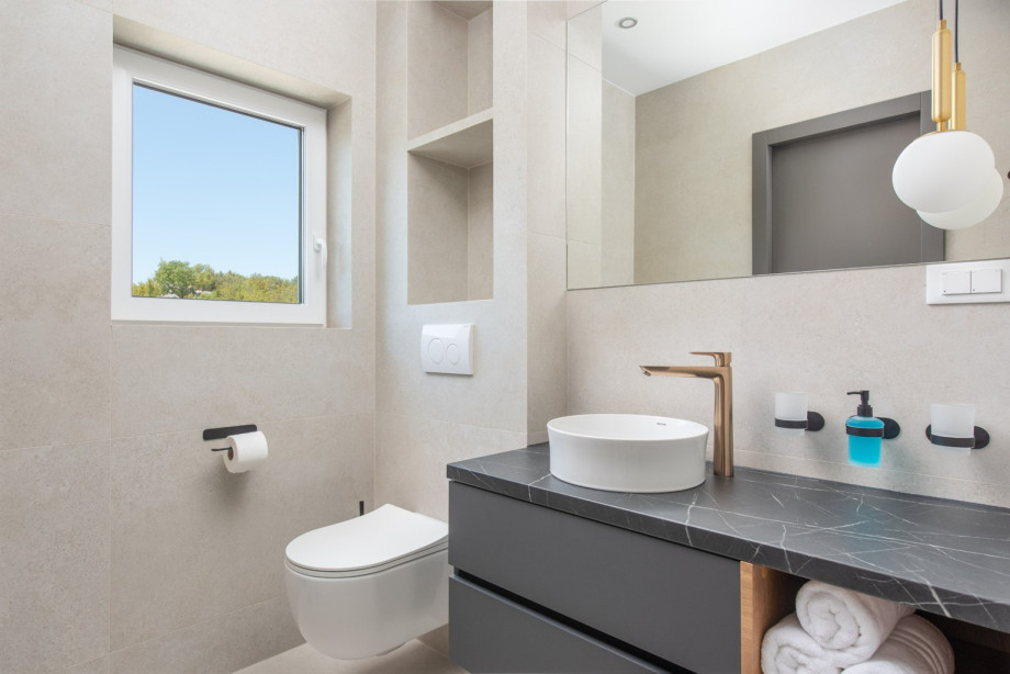 Stylish en-suite bathroom featuring a walk-in shower and natural light.