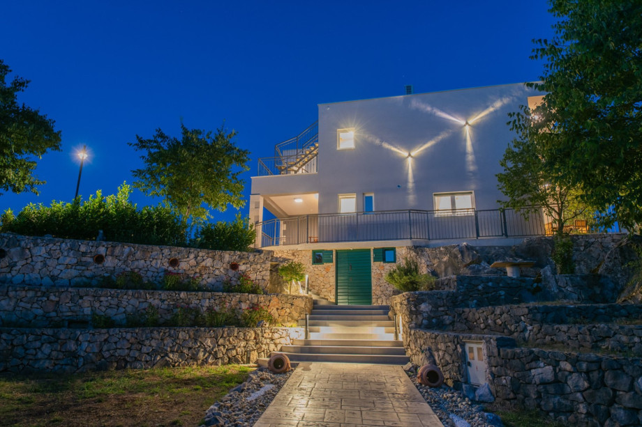 Stone-walled tiered gardens and lit stairs lead to the 230 sqm modern villa in Srijane.