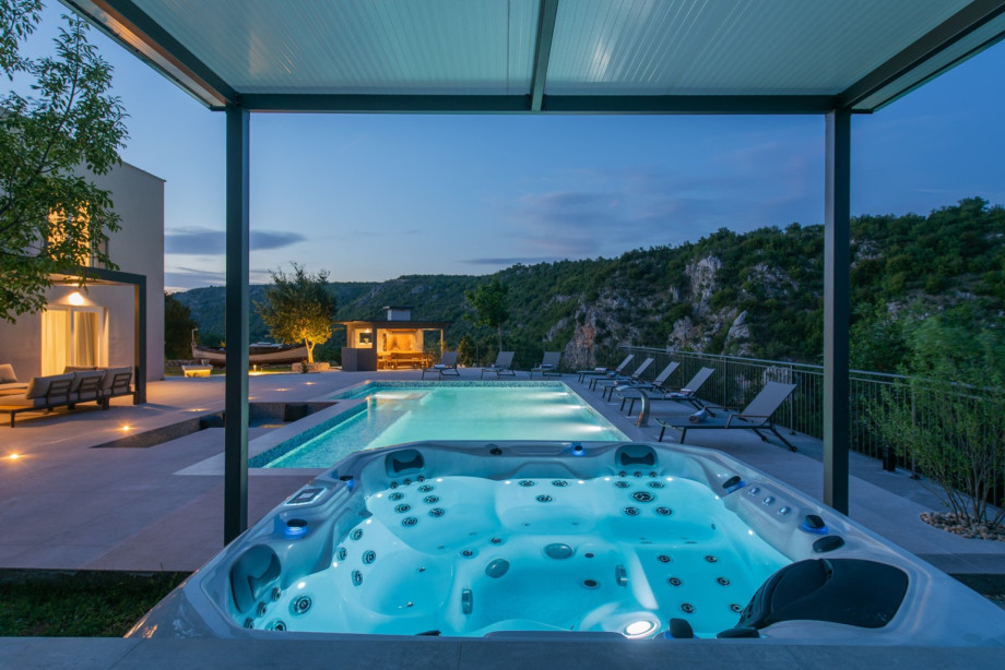 A covered Jacuzzi for 5 people overlooks the pool and the unspoiled natural environment.