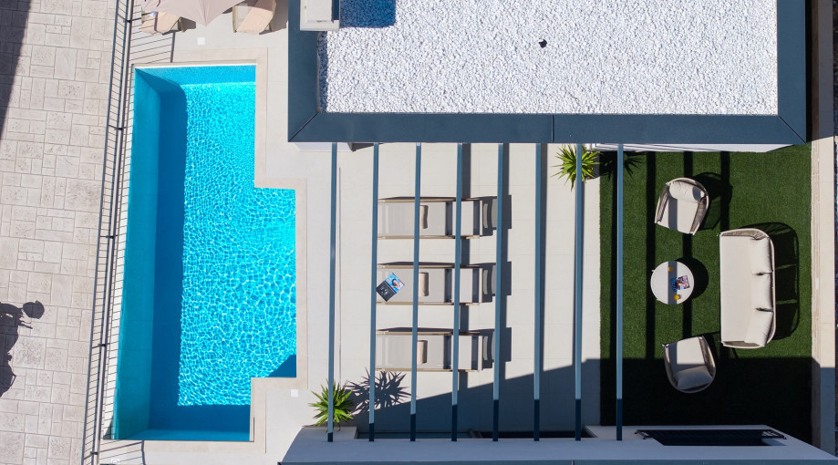 An aerial view shows the 7m x 3m heated pool and the cozy outdoor lounge corner for relaxation.