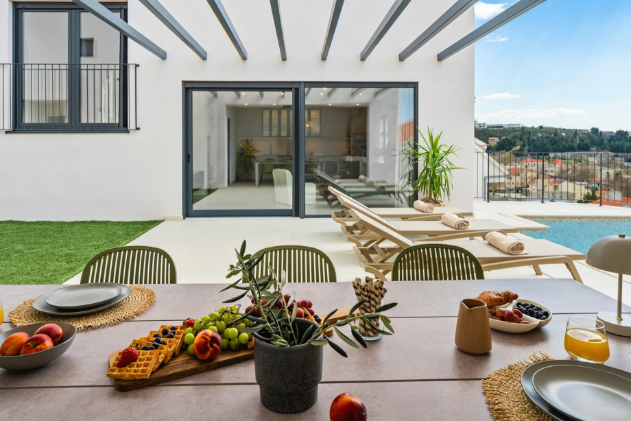 Large sliding doors create a seamless flow between the indoor living area and the outdoor pool.