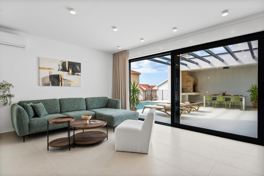 Relax on the comfortable sofa in the air-conditioned living room with direct access to the pool.