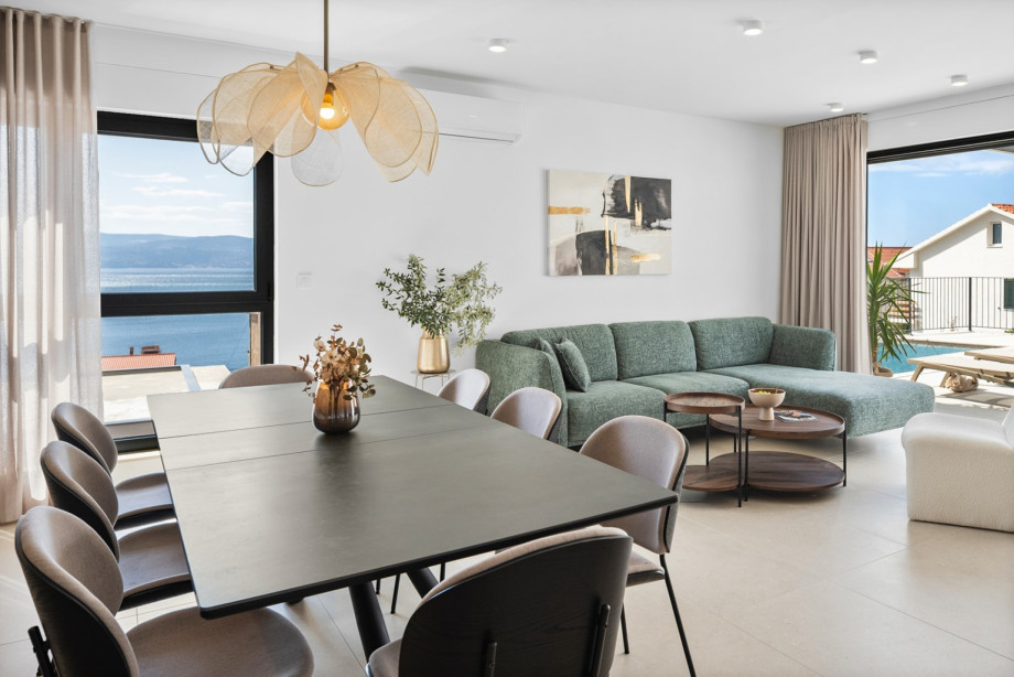 The stylish dining area offers beautiful sea views and comfortable seating for family gatherings.