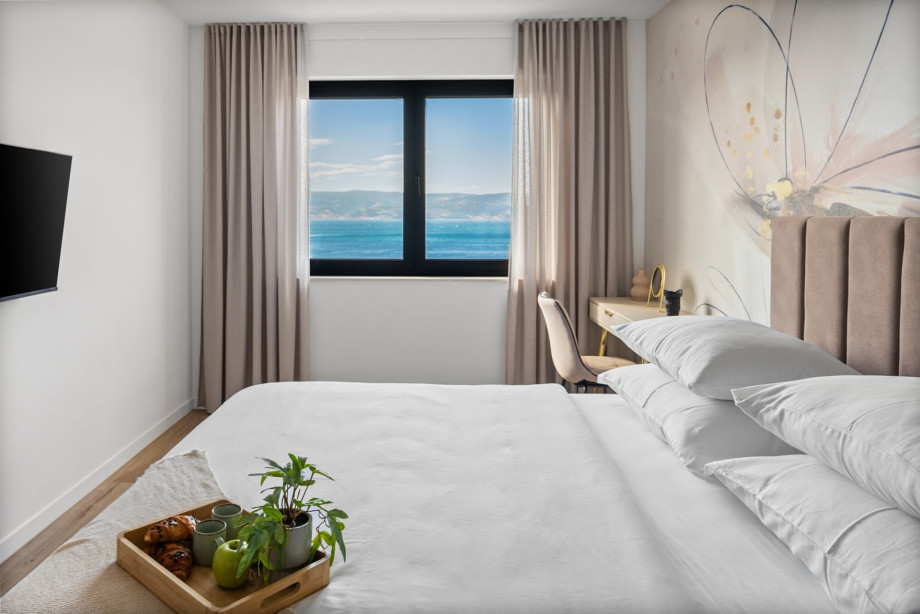 The first bedroom offers stunning sea views and a comfortable king-size bed for relaxation.