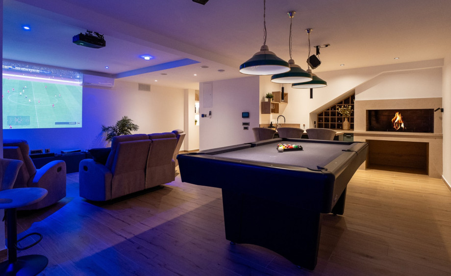 Ein zusätzliches Wohnzimmer, das als Unterhaltungsbereich mit einem Grillplatz im Innenbereich eingerichtet ist