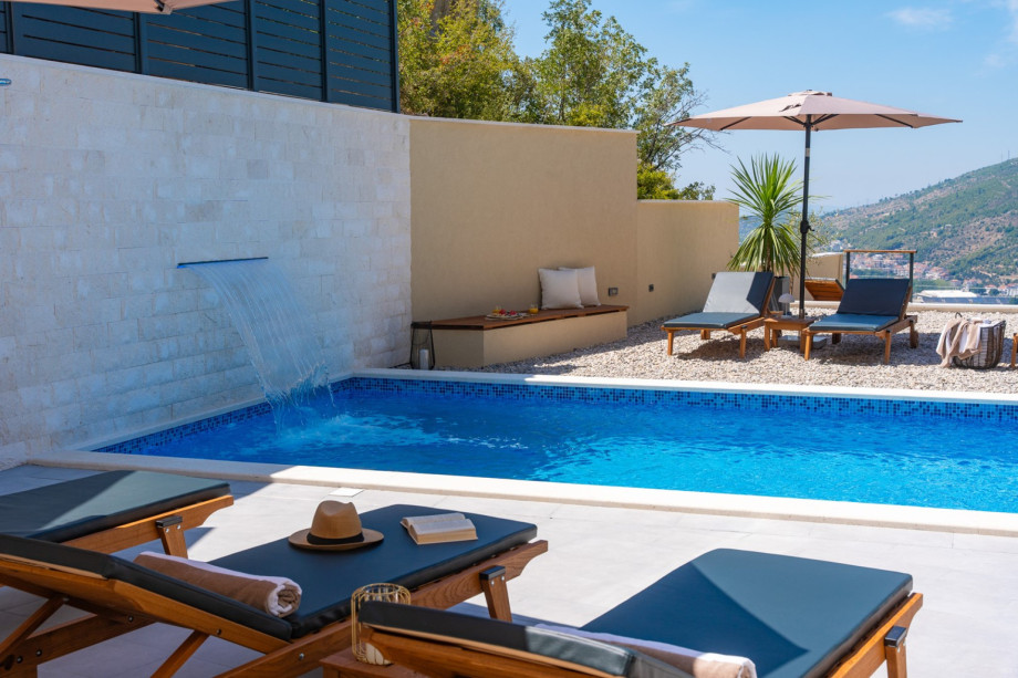 Sonnendeck mit acht Liegen direkt neben dem Pool