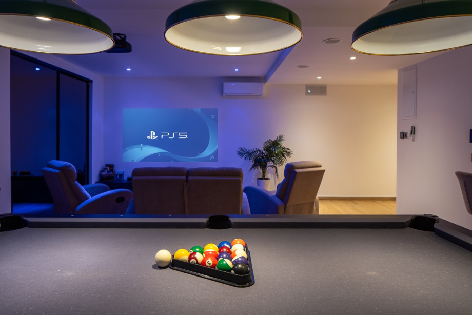 A cozy hangout space combining cinema vibes with a classic billiards setup