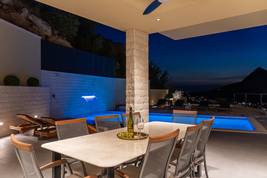 Outdoor area with heated pool and large sunbathing area with eight loungers