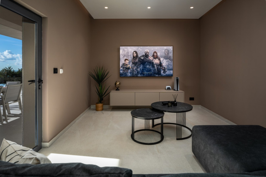 Media room (18 sqm) with sofas, a flat screen TV, a PlayStation 5, and air-conditioning