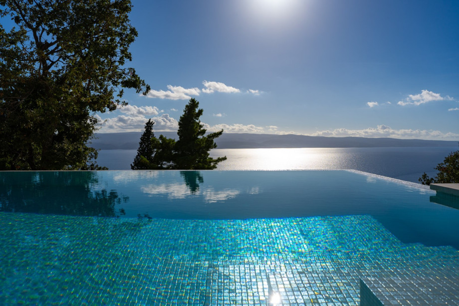 The pool area with ambient night lighting provides a soothing and peaceful background while enjoying the views of the town Omiš underneath