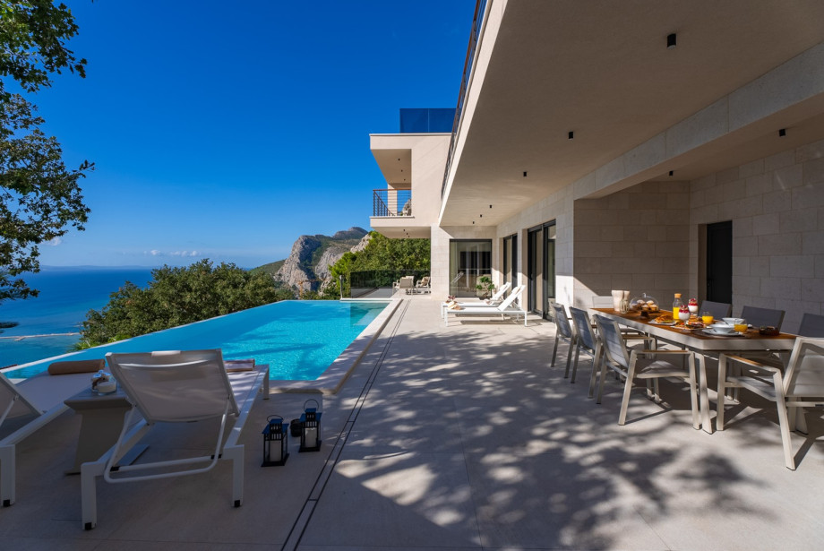 Covered outdoor dining area with a barbecue (gas), and the outdoor shower.