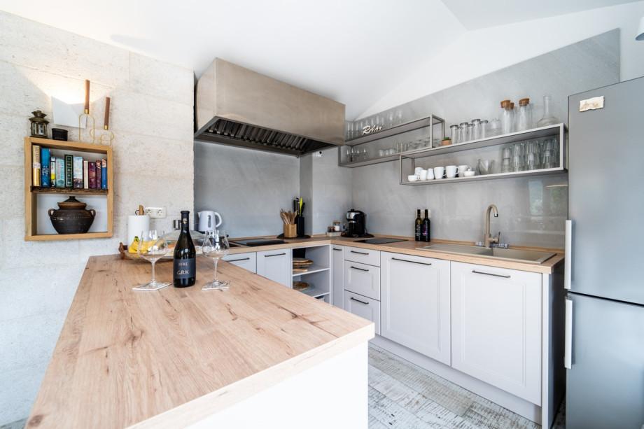 Summer kitchen with a dining table for 10 people with sliding glass doors toward the pool