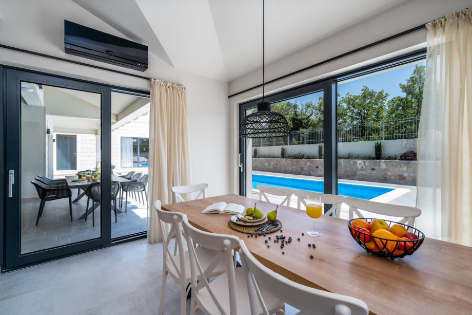 Dining table and a direct approach to the pool area and to the outdoor dining area