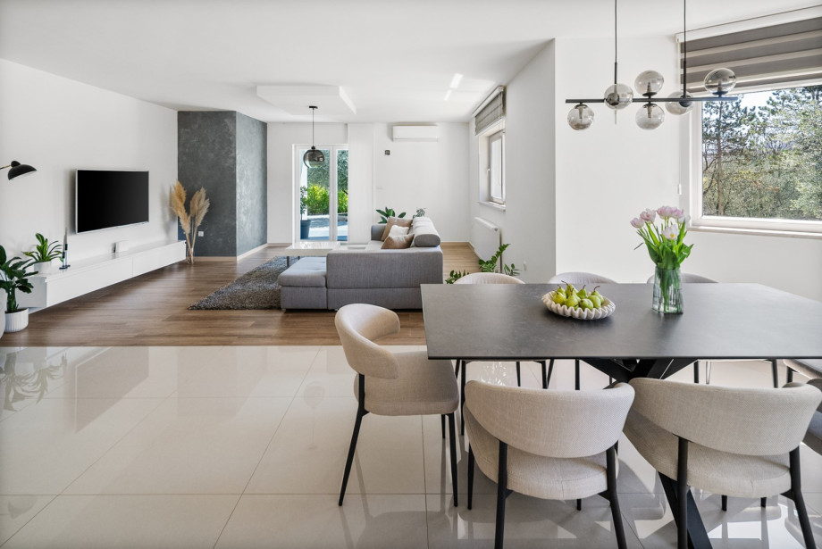 The open-plan living area integrates a fully equipped kitchen, dining area, and a lounge with a flat-screen TV.