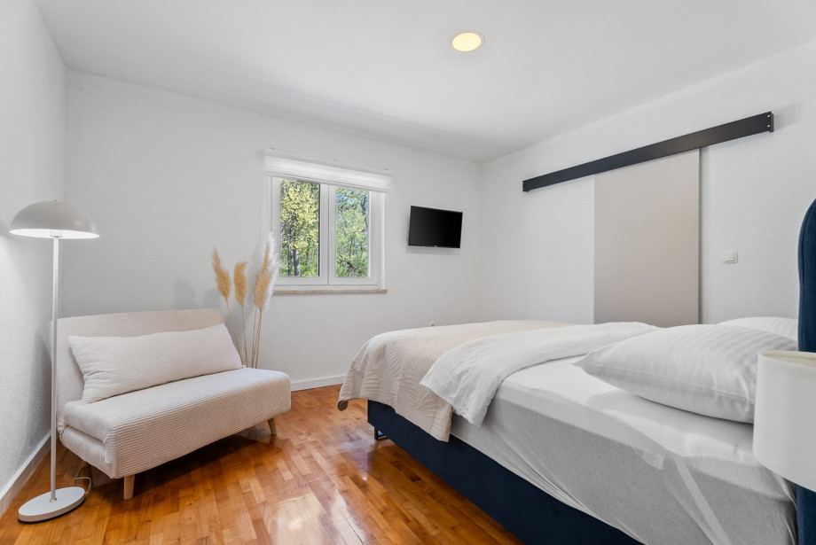 The room includes a walk-in wardrobe and a TV.