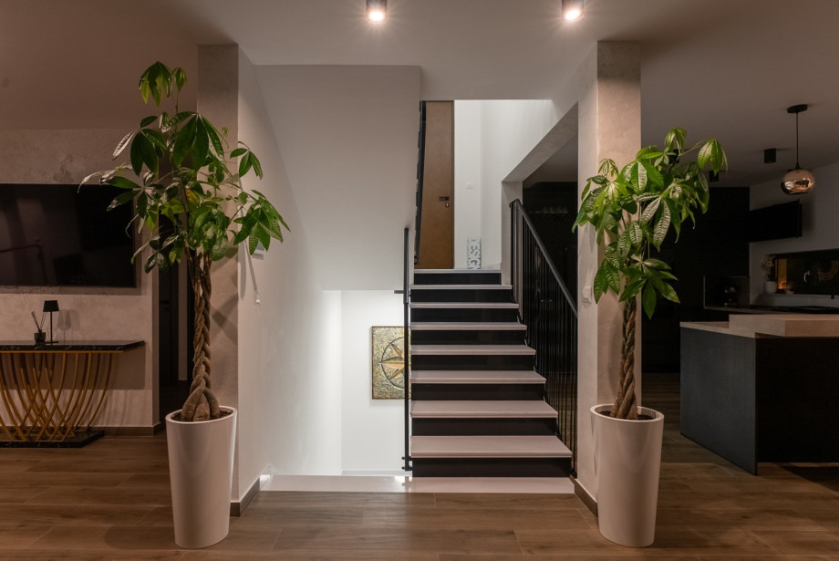 Modern interior with a staircase leading to the bedrooms upstairs and the wellness area downstairs.