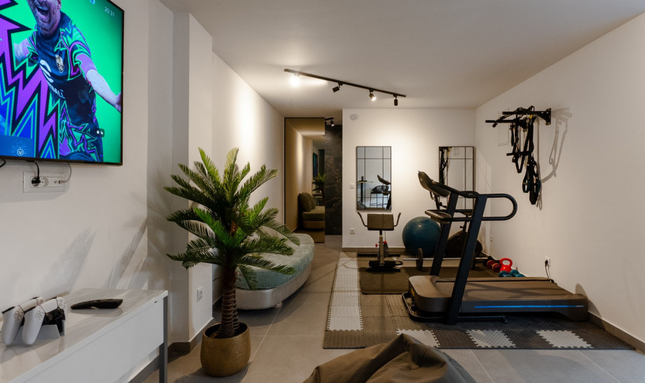 A small fitness space with equipment like an exercise bike and pilates ball