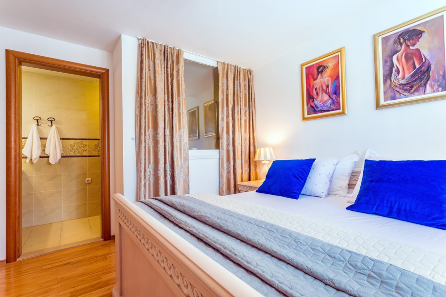 Bedroom No1. with double bed, TV, and en-suite bathroom with bathtub (pool level)