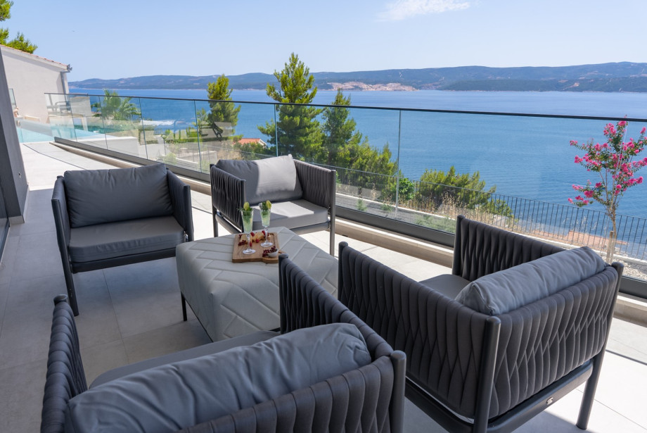 Relax in the outdoor lounge area with a refreshing drink, perfect for unwinding in the afternoon sun