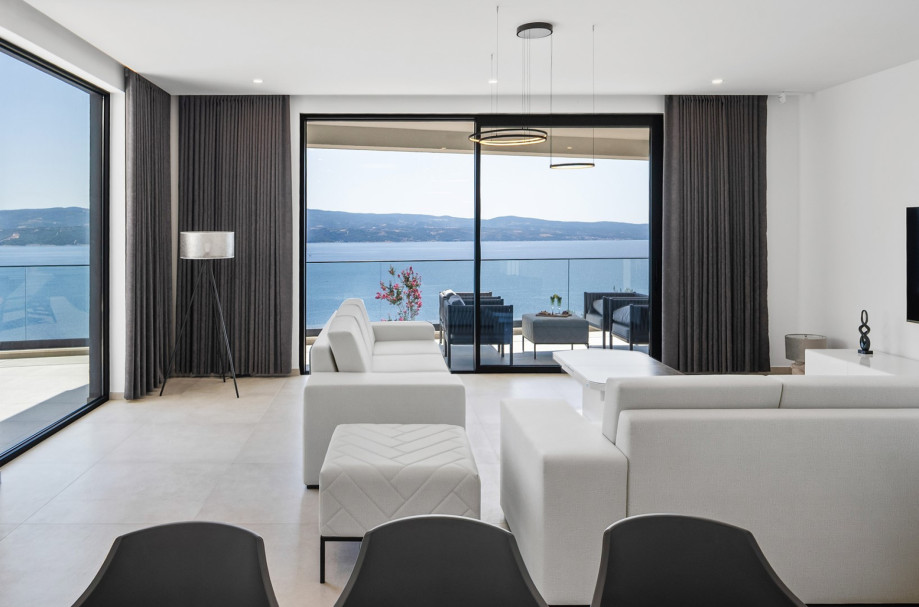 The ground floor boasts a spacious living-dining area that seamlessly opens up to the pool