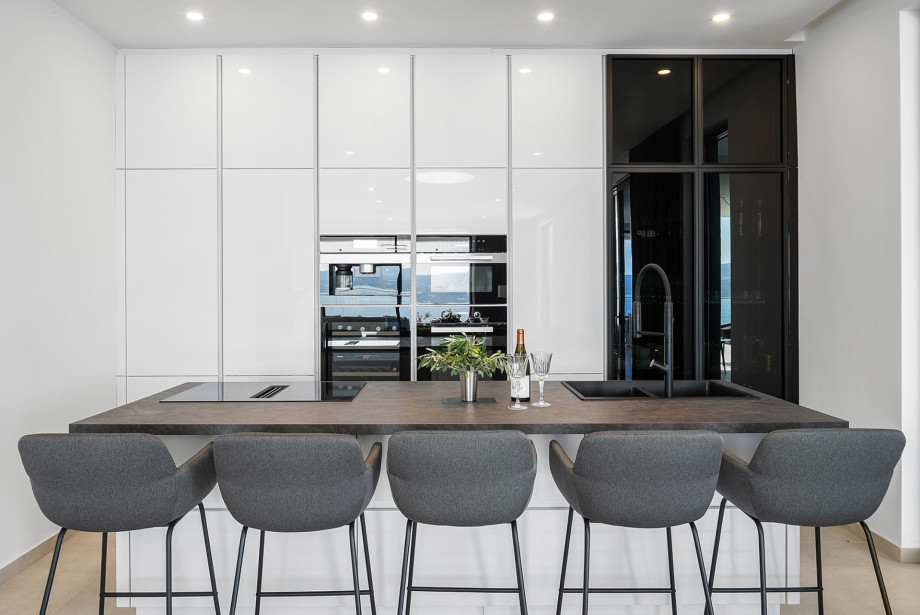The kitchen includes amenities such as a refrigerator, espresso machine, wine cooler, four-burner electric cooktop, dishwasher, microwave, oven, and toaster