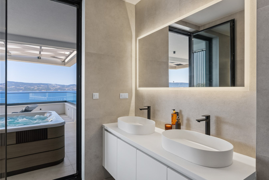 En-suite bathroom with a walk-in shower, double sink, and toilet