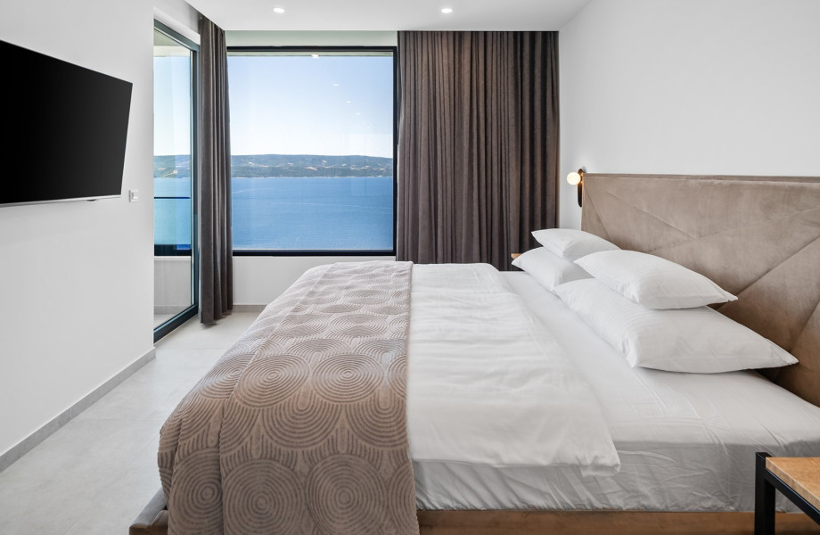 Bedroom No. 3 with a king-size bed, TV, air conditioning, and a balcony with beautiful sea views
