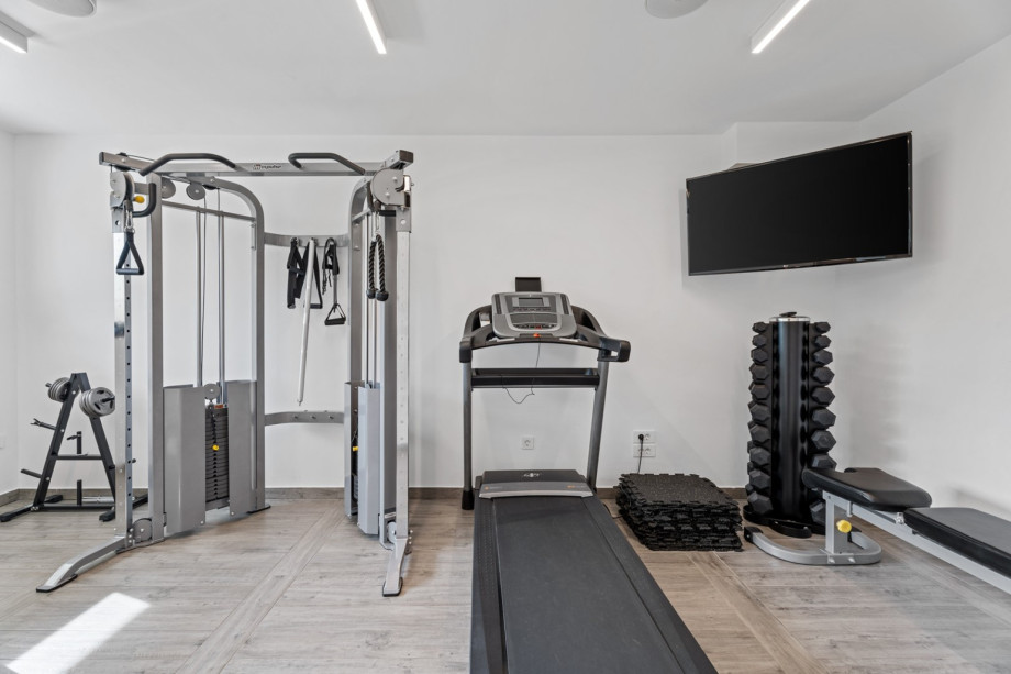 Gym at lower ground floor with few devices and TV
