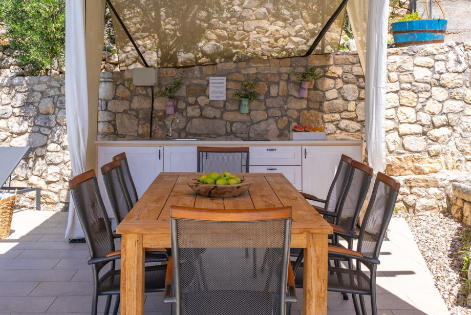 Outdoor kitchen and dining table at the pool area.