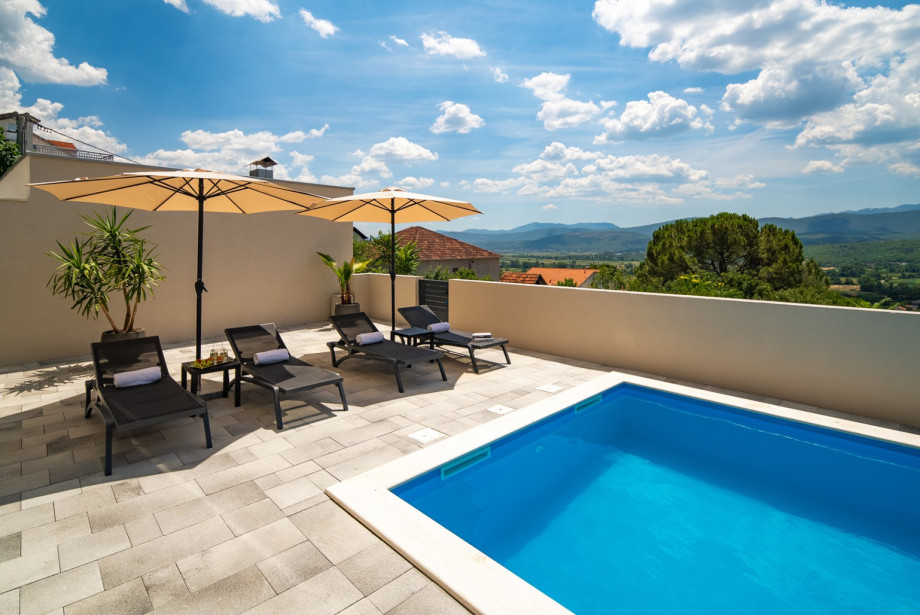 Sun terrace with 10 comfortable sun loungers and parasols with a beautiful view of the landscape