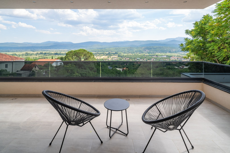 Bedroom No. 2 offers access to a terrace with a table for two and a beautiful view of the landscape.