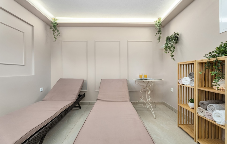 The serene spa zone features a relaxation room with two lounge chairs, perfect for unwinding after a swim.