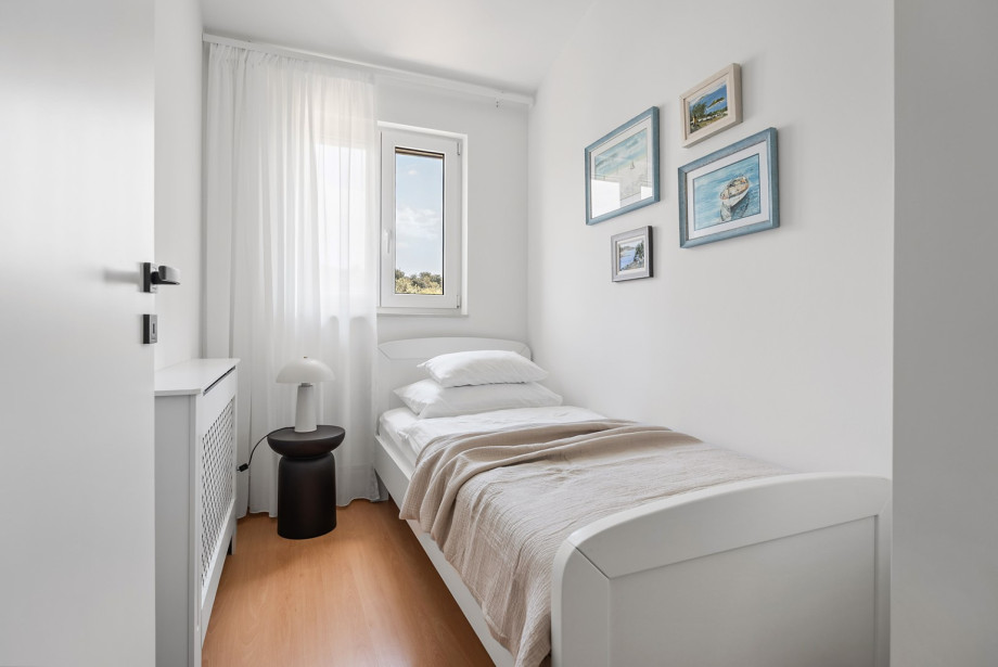 One of the cosy single bedrooms offers a comfortable bed and natural light, perfect for a peaceful rest.