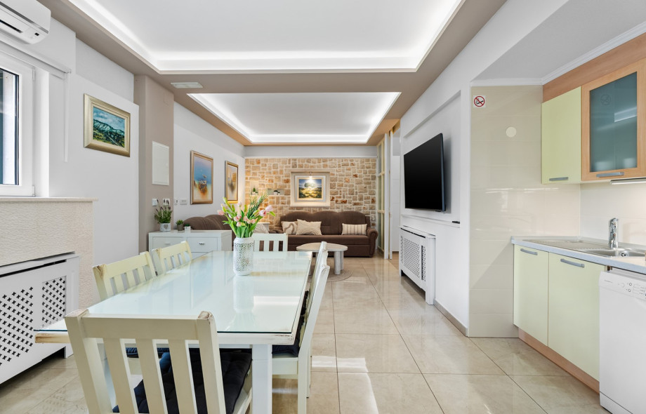 The open-plan kitchen and dining area of one apartment boasts a dining table for 6 and a fully equipped kitchen.