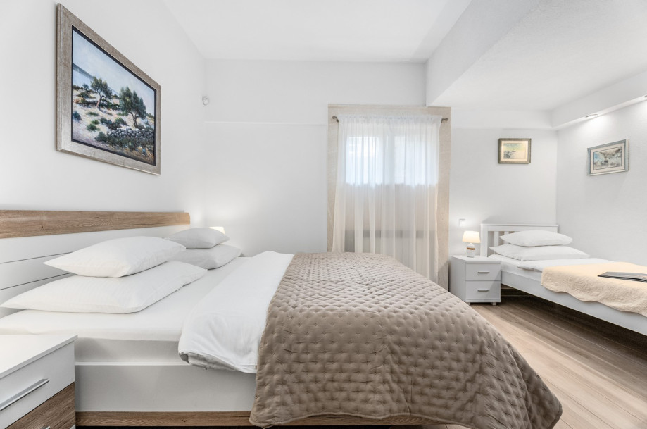 A 16 sqm bedroom featuring a king-size bed (180cm x 200cm) and an extra single bed.