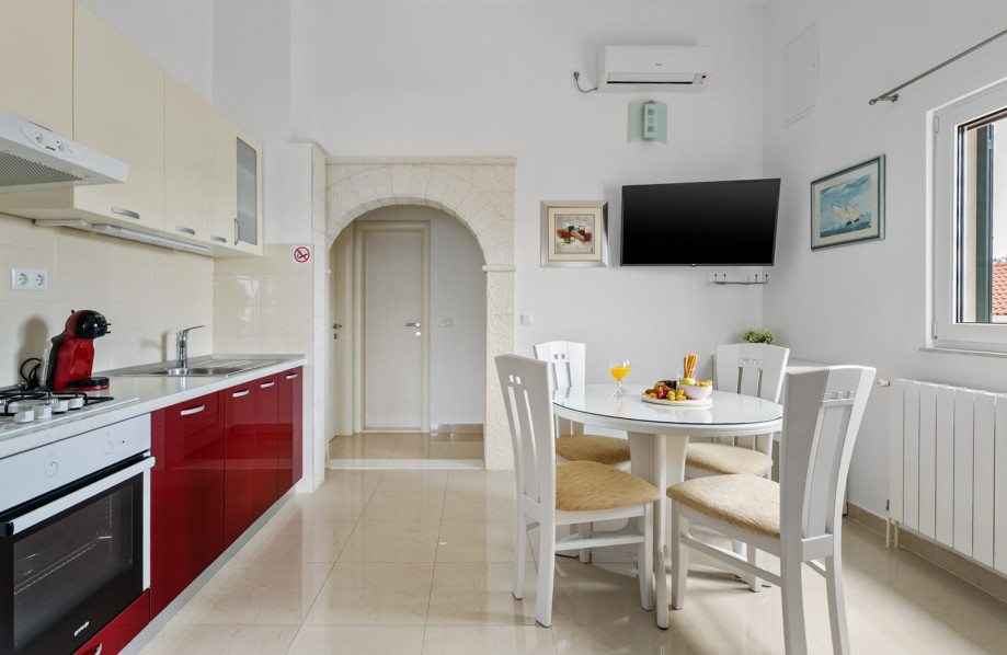 A 16 sqm living area with a kitchen, sofa, TV, and dining space for 4 people.